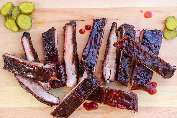 pork spare ribs sliced on cutting board with pickes