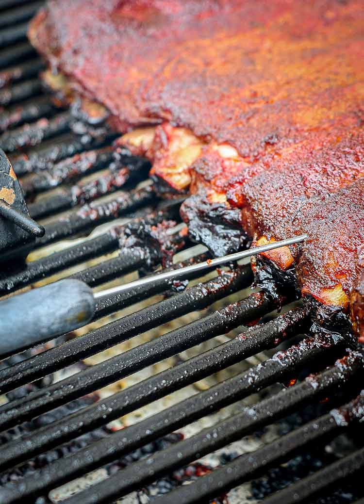 using meat thermometer to check temperature of ribs