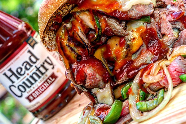 Ingredient Spotlight Head Country Bar-B-Q Sauce head country bar-b-q sauce next to sandwich on cutting board