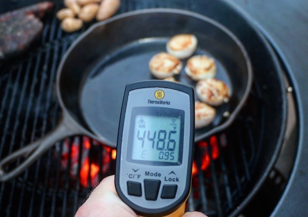 thermoworks infrared thermometer readout of cast iron pan on grill
