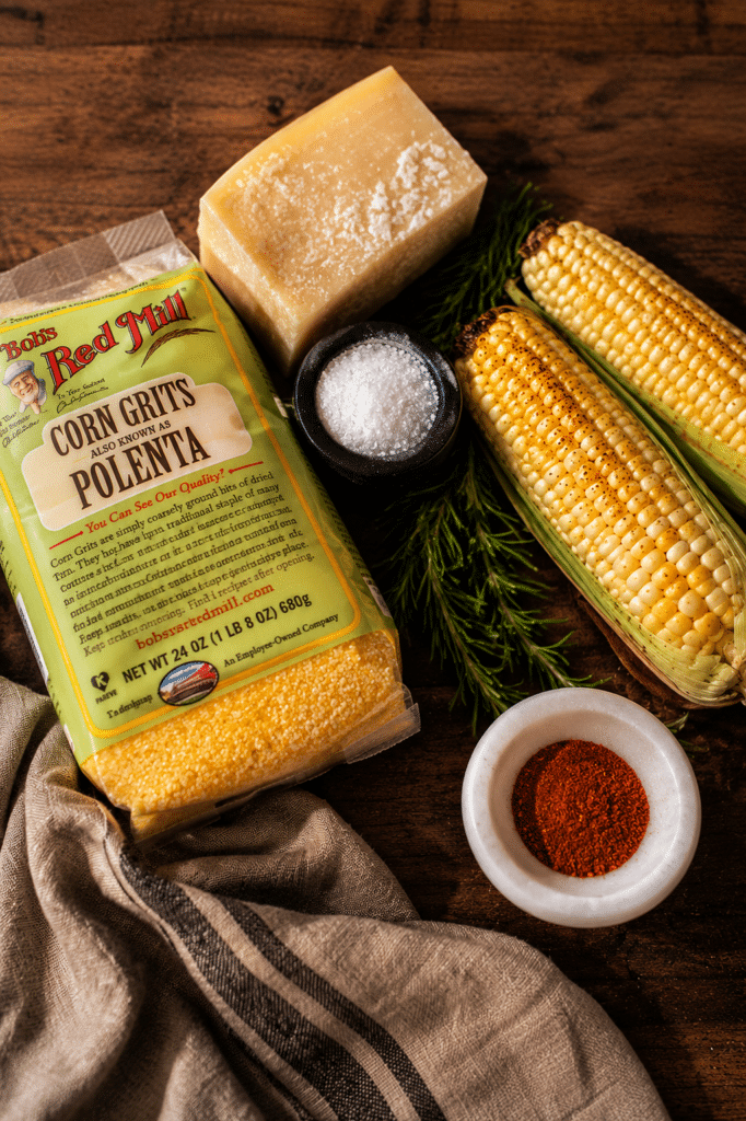 ingredients for creamy corn polenta sitting on a wood cutting board