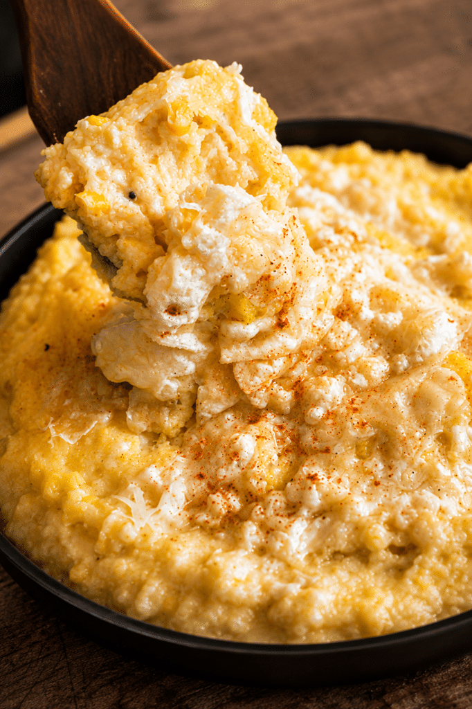 corn polenta on a wooden spoon over a saucepan