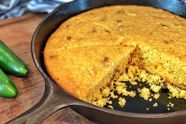 cheddar jalapeño cornbread sliced in cast iron pan