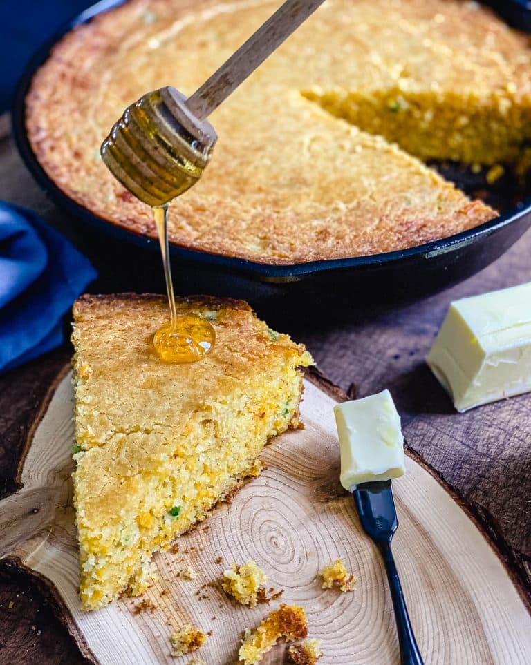 honey being drizzled onto cheddar and jalapeno cornbread