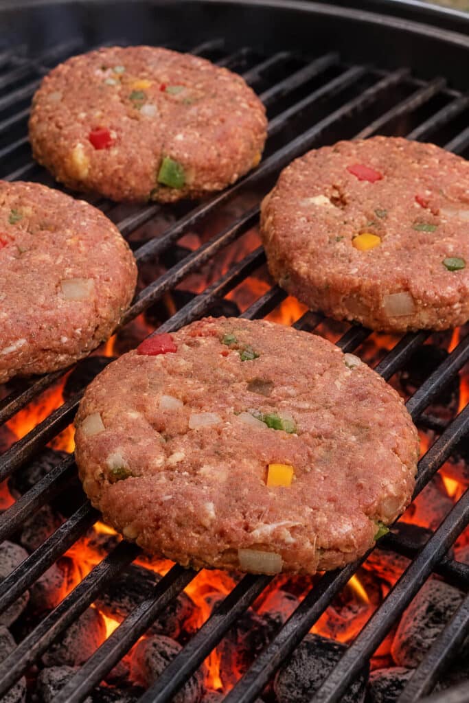 mac-n-cheese meatloaf burgers cooking over hot coals on a grill