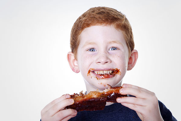 kid enjoying barbecued ribs