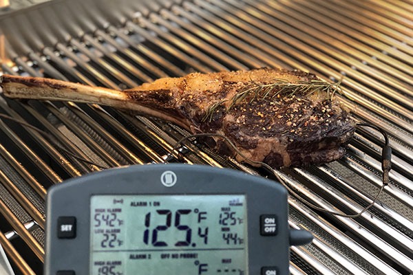Tomahawk steak heated to temperature on a grill