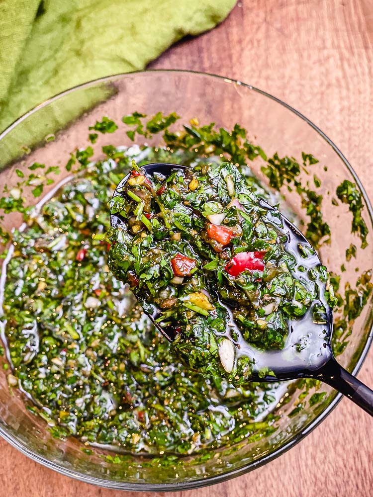 chimichurri sauce on a spoon over a bowl