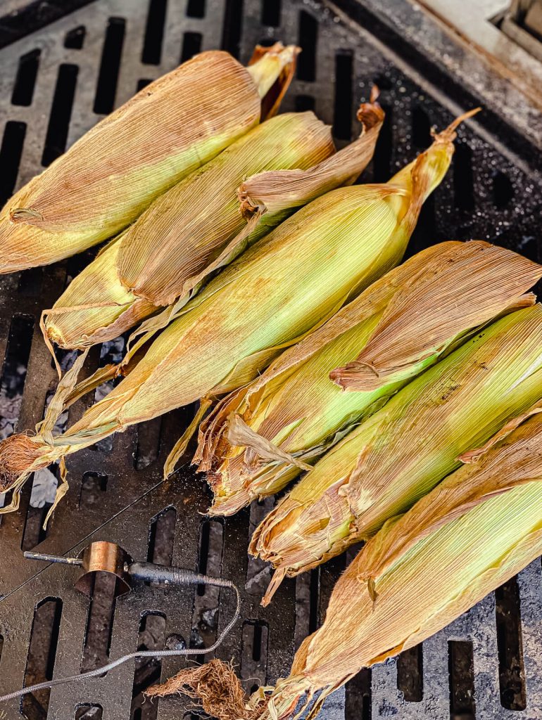 corn on the cob in the husk on a grill