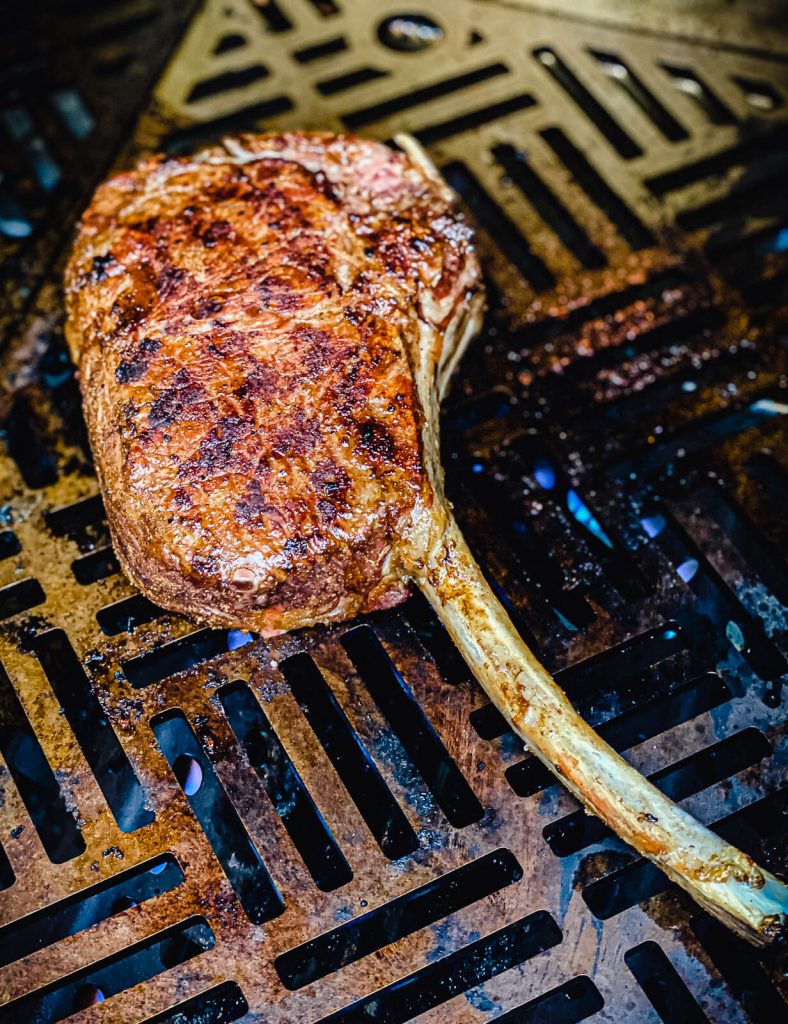 tomahawk ribeye searing on a gas grill