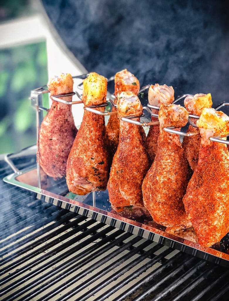 smoked chicken drumsticks on the grill with smoke rolling