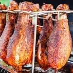 chicken drumsticks hanging in a cooking rack