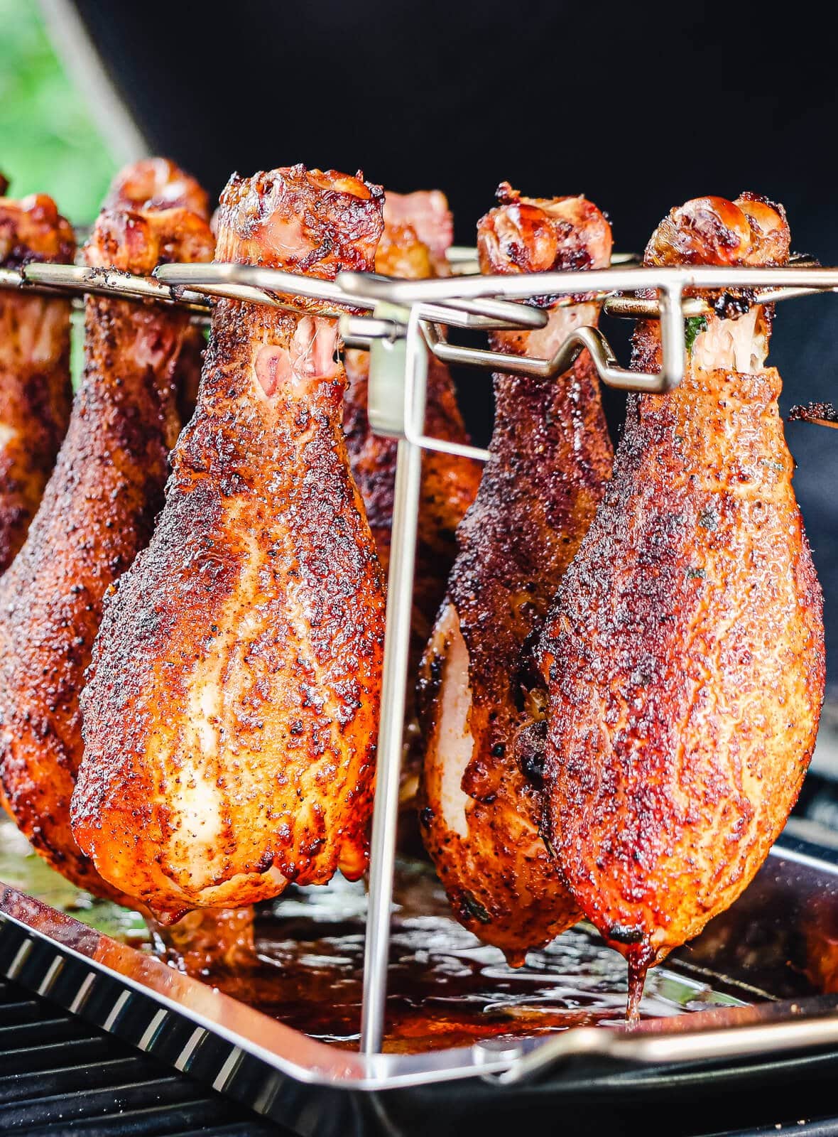 chicken drumsticks hanging in a cooking rack