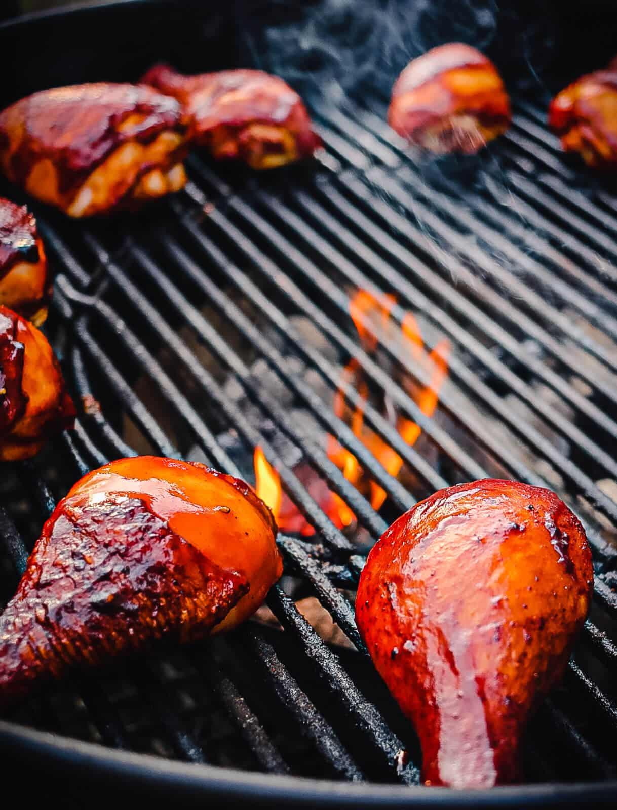 chicken drumsticks cooking over indirect heat on a grill