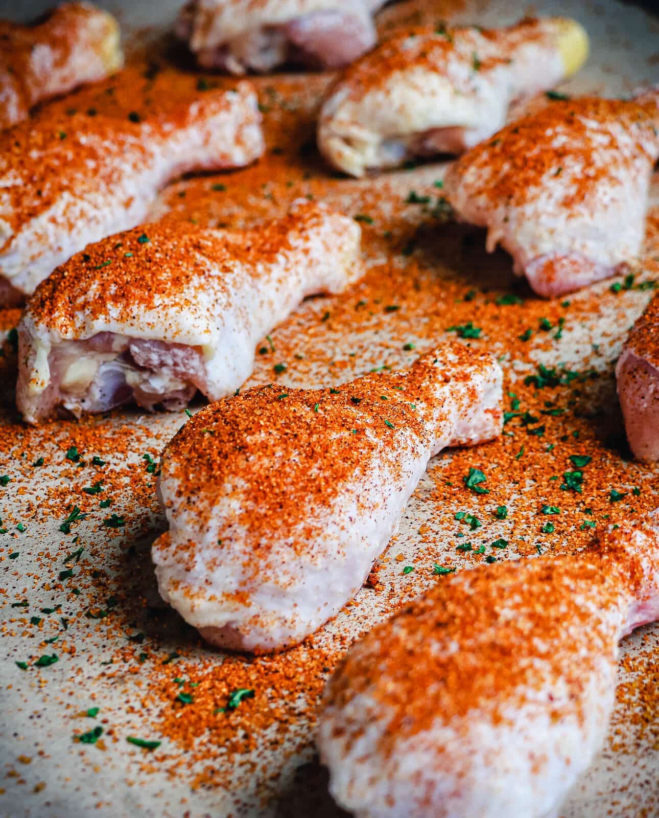 chicken drumsticks being seasoned for smoking