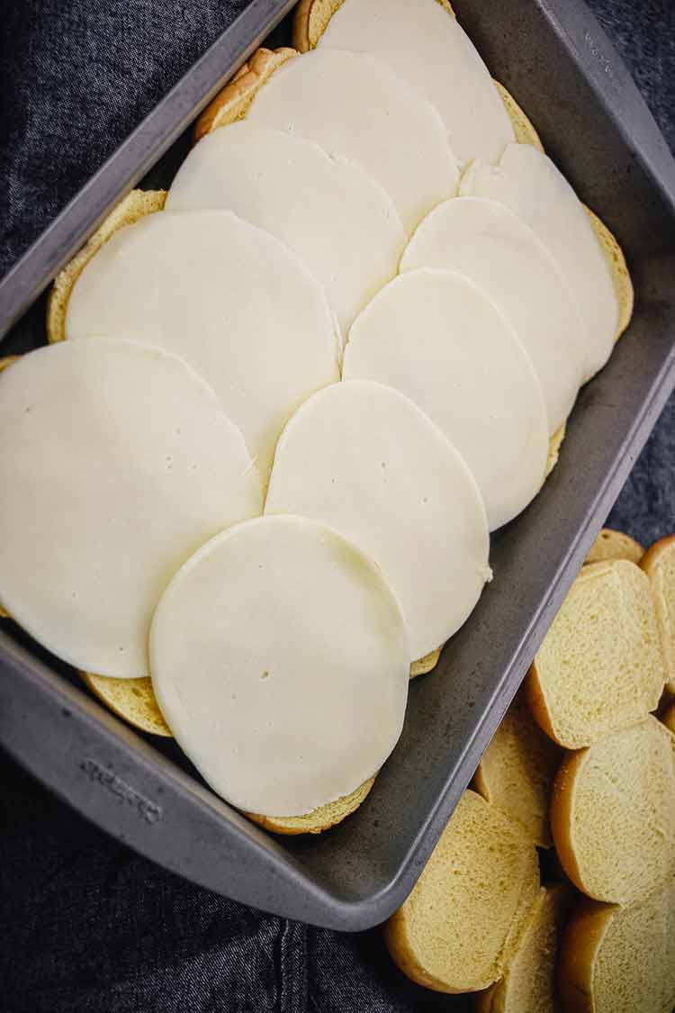 Provolone cheese added to slider buns for the Cheesesteak Sliders