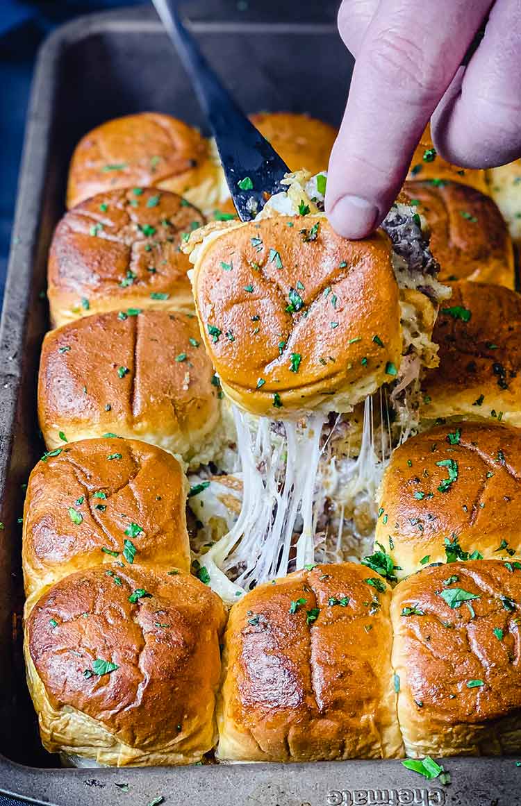 Completed pan of Philly Cheesesteak Sliders with garlic butter on the side