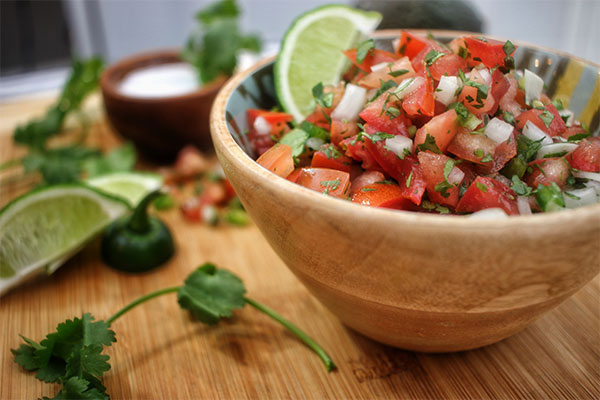 Pico de gallo in a bowl with limes