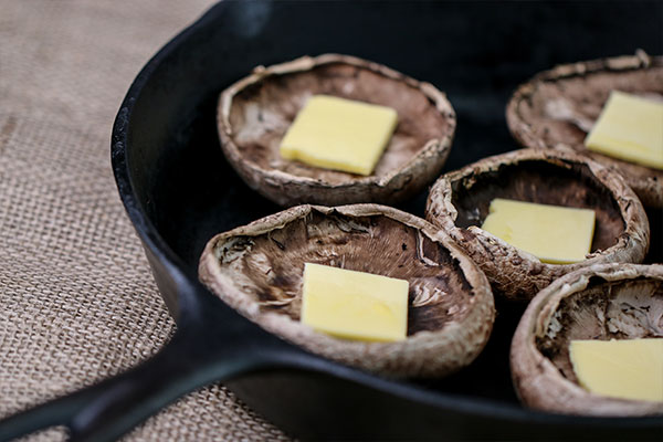 portobello mushroom with butter in cast iron pan for crab stuffed mushroom recipe