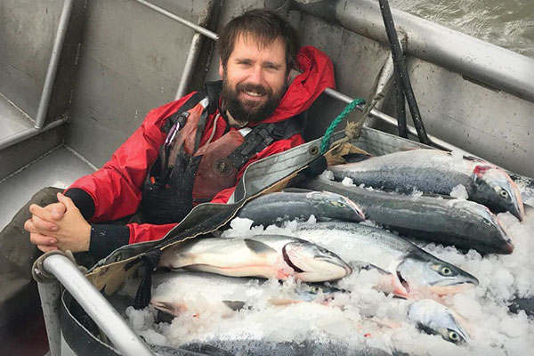 Traveler Terpening next to his salmon catch