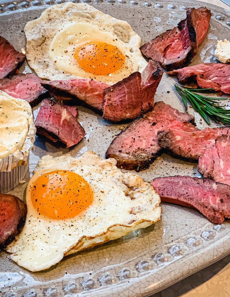 steak and eggs in sage butter on a platter