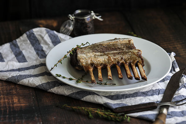 Rotisserie Rosemary Crusted Lamb on a platter ready for serving