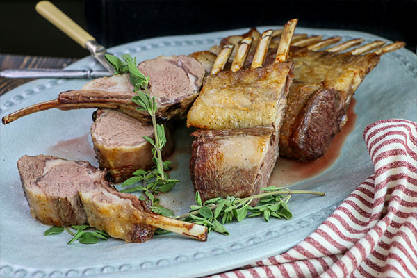 Rotisserie Rosemary Crusted Lamb sliced and served on a platter