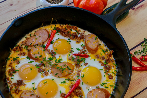 breakfast-grilling-featured eggs and sausage in a cast iron skillet