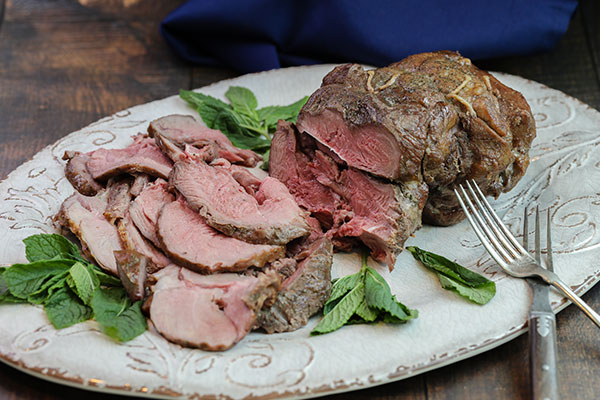 Rotisserie Boneless Leg of Lamb sliced on a serving platter and ready to eat