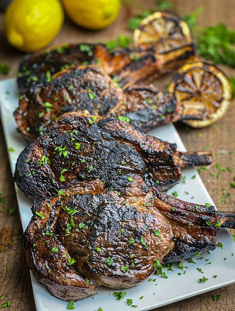 Veal Piccata plated with charred lemons and asparagus