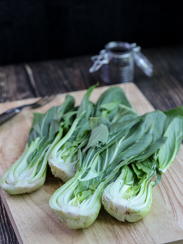 Clean baby bok choy sliced in half for Spicy Grilled Baby Bok Choy recipe