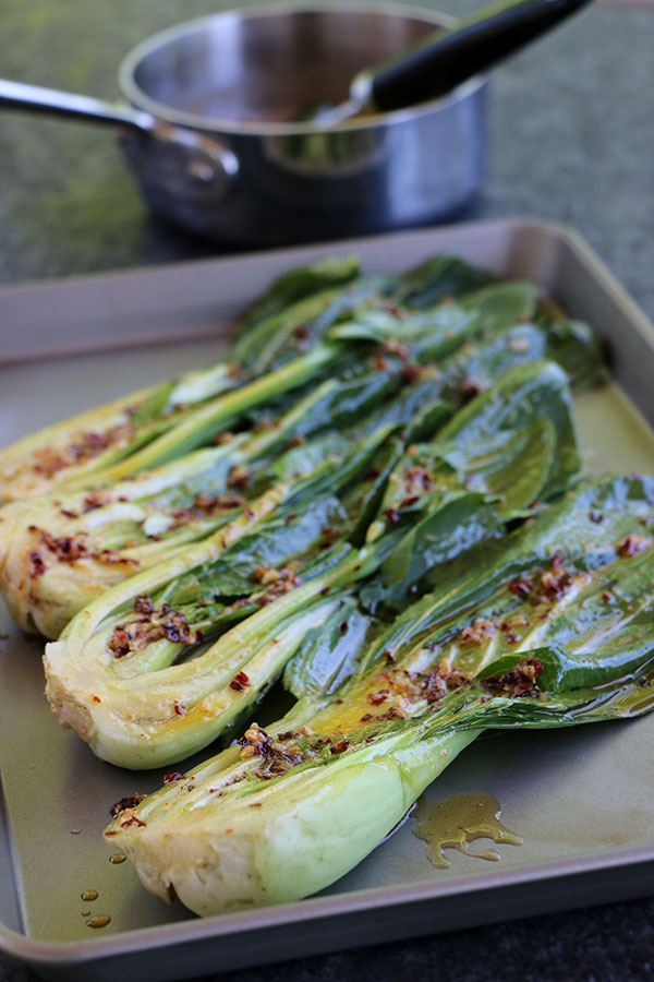 Spicy sauce spread over baby bok choy halves