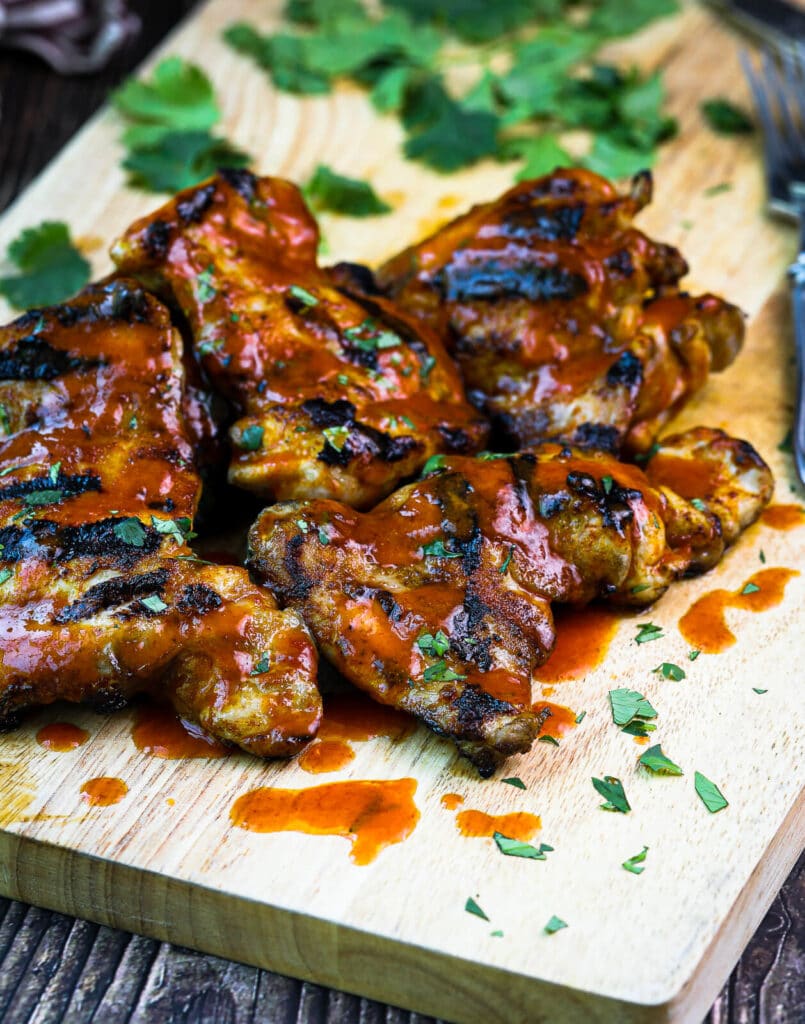 grilled honey sriracha chicken thighs on a cutting board