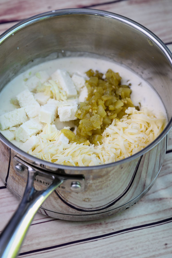 cheese, chiles and milk melting in a saucepan for queso fresco 