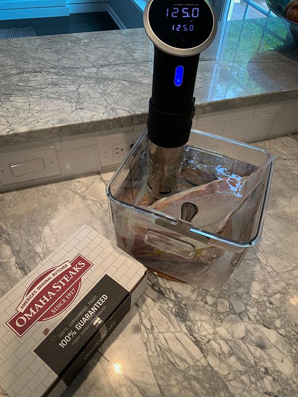 Sous vide NY strip steak in water bath cooking