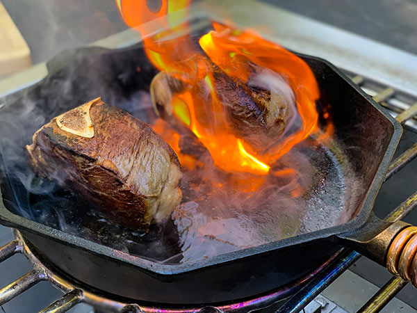 searing bone in filet mignon on a cast iron pan