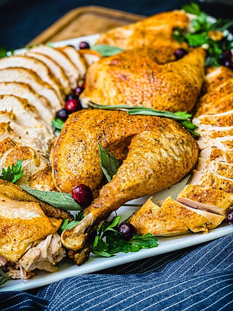 sliced turkey on a platter with cranberries