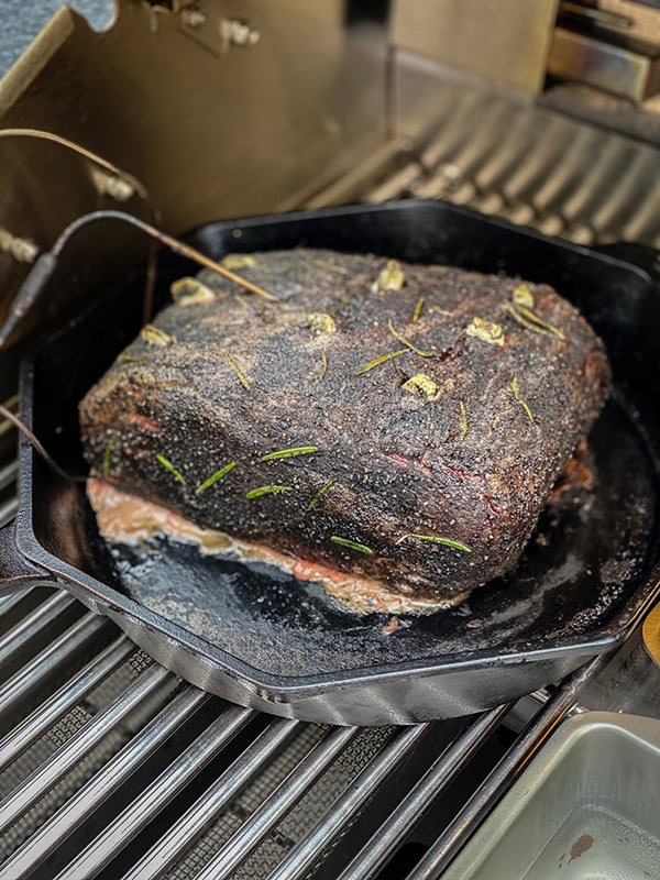 searing meat on a grill in a cast iron skillet
