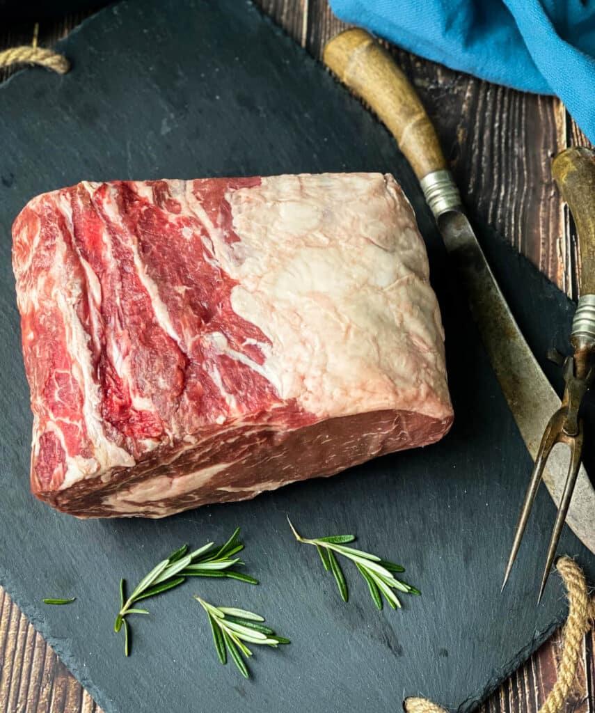 uncooked prime rib on a cutting board