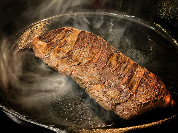 Pan searing skirt steak on a cast iron skillet