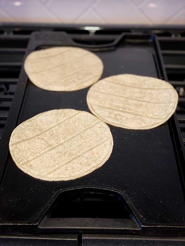 corn tortilla warming on the griddle