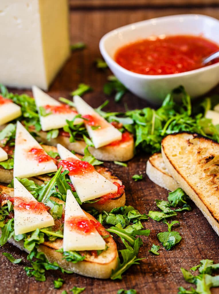 cutting board with manchego cheese and tomato bread appetizer