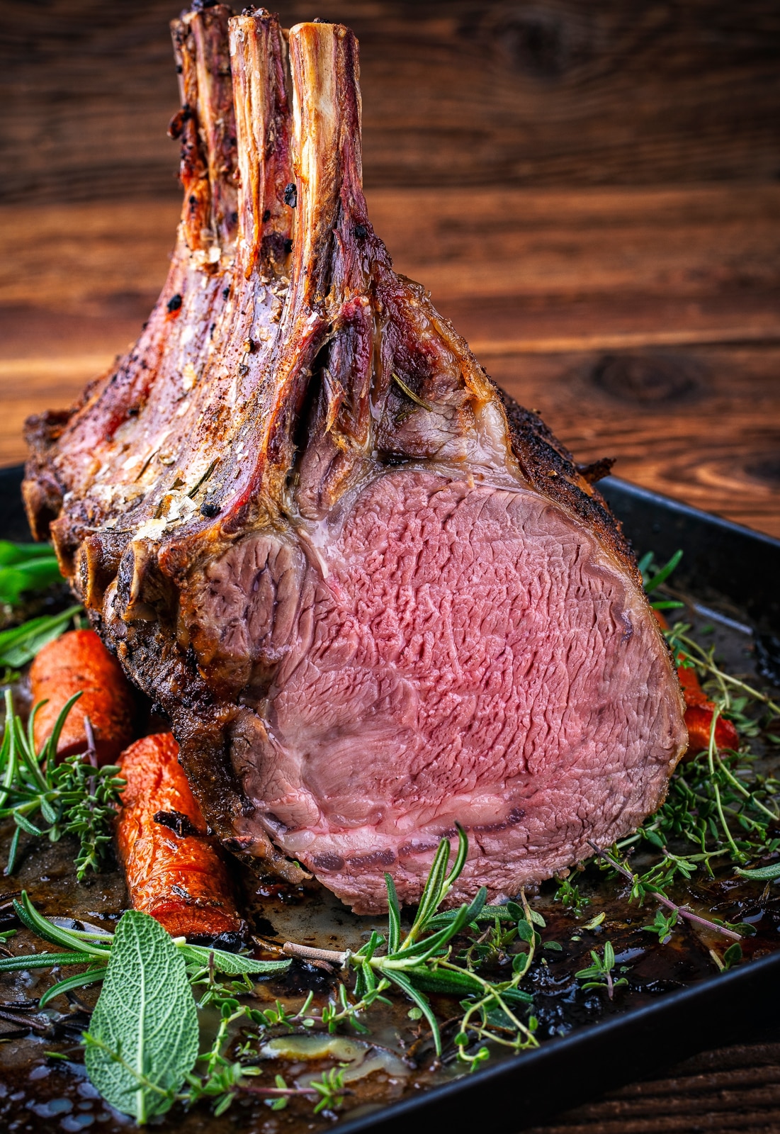 herb crusted rack of veal on a platter of herbs