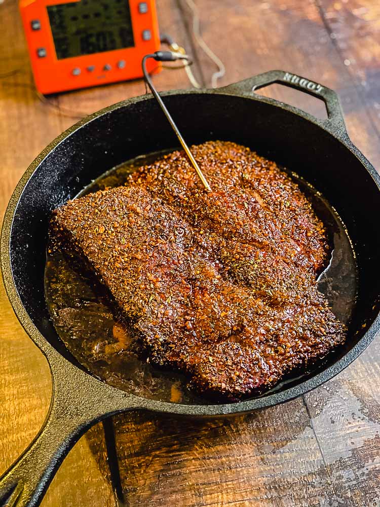 Smoked Beef Chuck Roast cooking in a cast iron pan