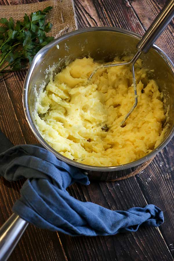 Season roasted garlic butter mashed potatoes with salt and pepper