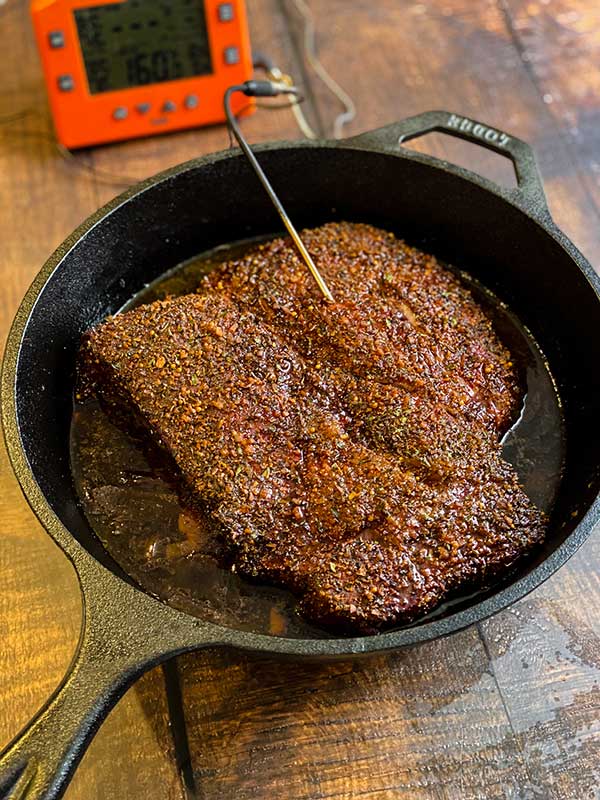 Smoked Beef Chuck Roast cooking in a cast iron pan