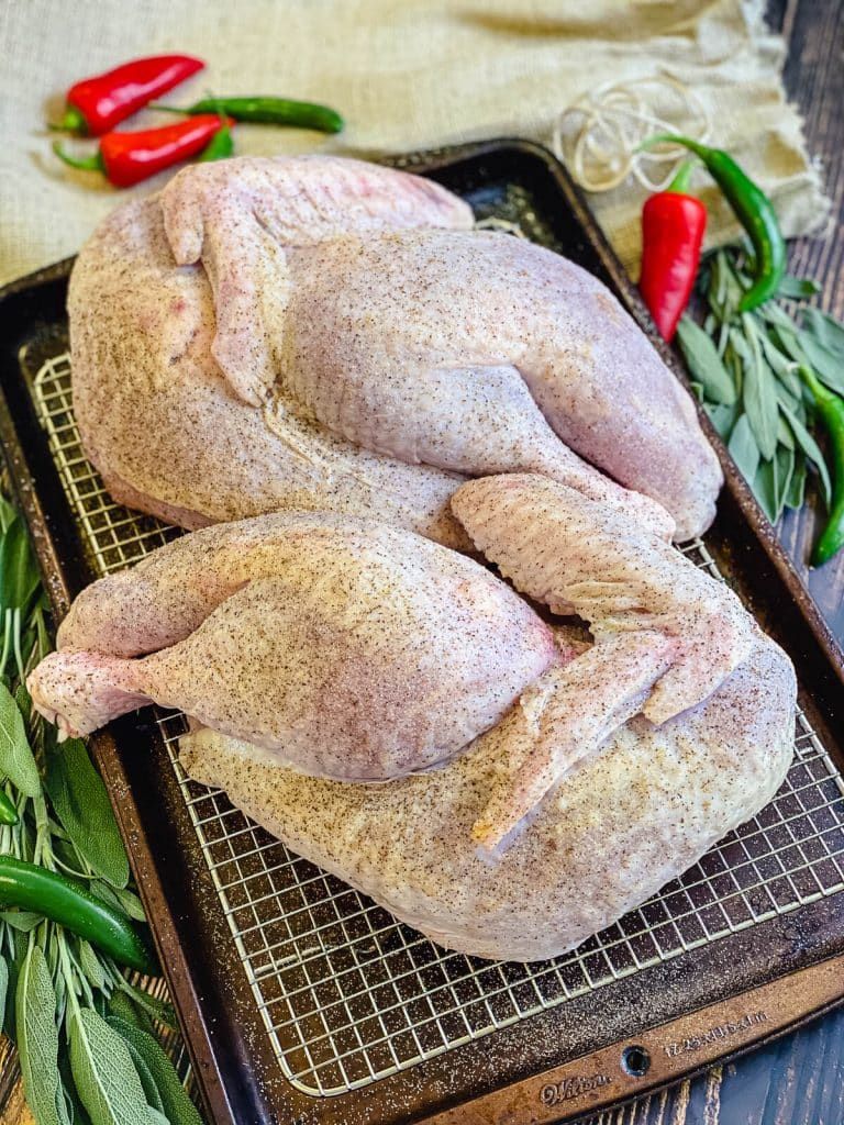 uncooked turkey halves on a wire rack