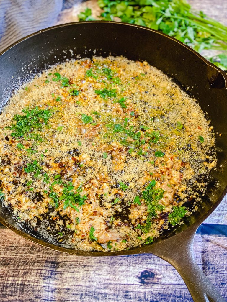 garlic parmesan with bacon sauce in cast iron pan