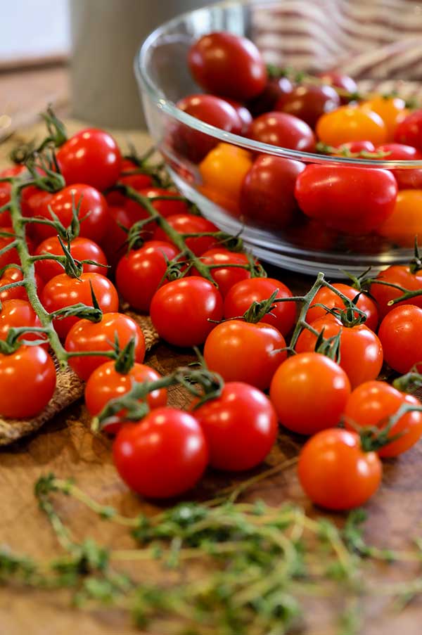 Fresh cherry tomatoes next to a bowl