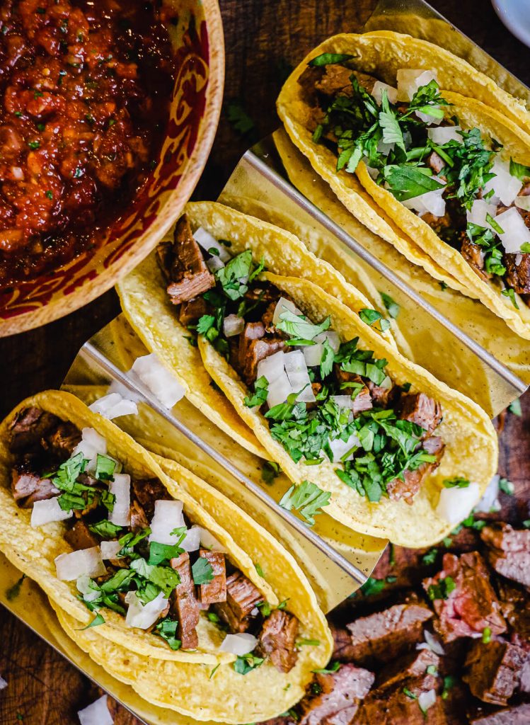 assembling Mexican street tacos in a taco tray